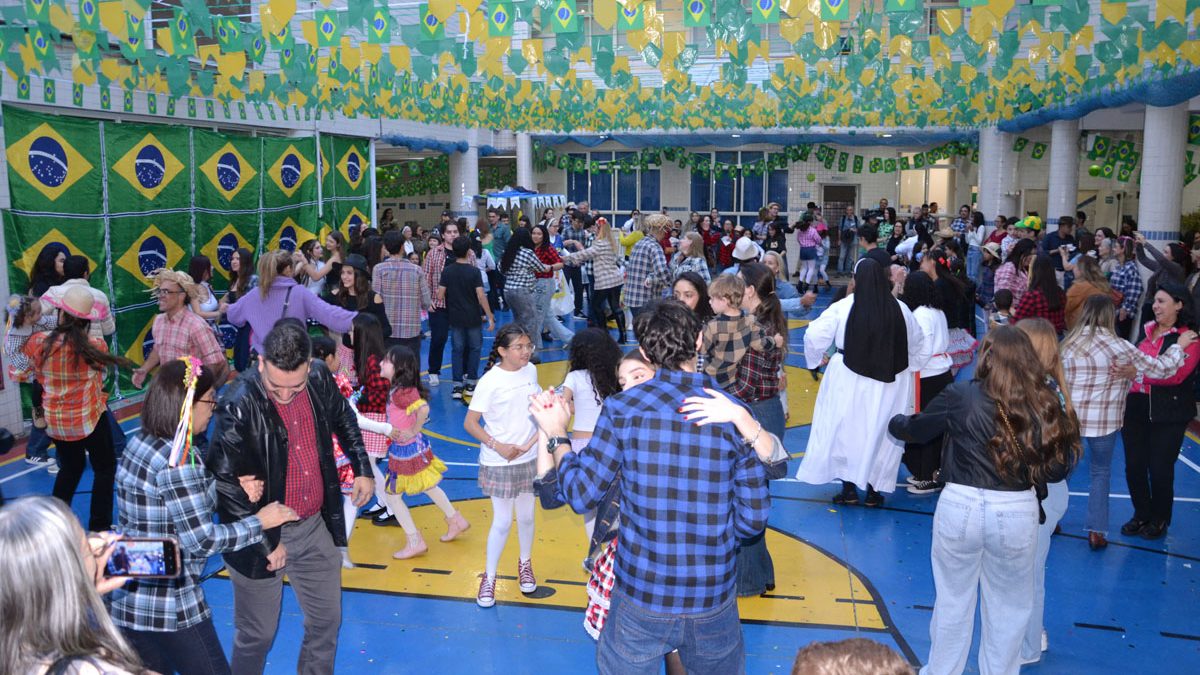 Alunos do Colégio Santa Catarina de Sena dançando quadrilha no Arraiá de 2026