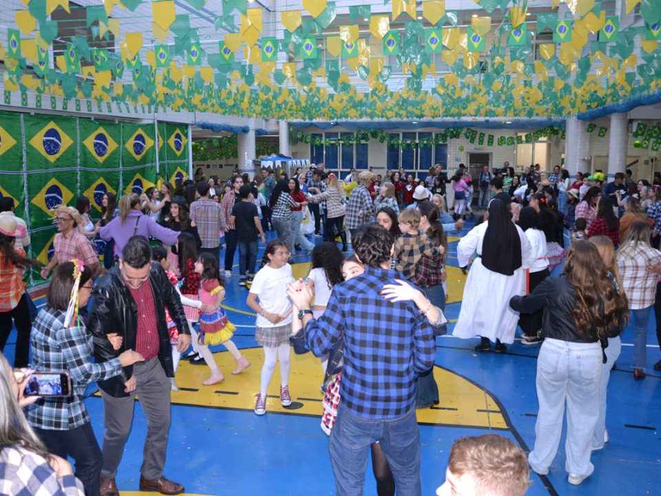Alunos do Colégio Santa Catarina de Sena dançando quadrilha no Arraiá de 2026